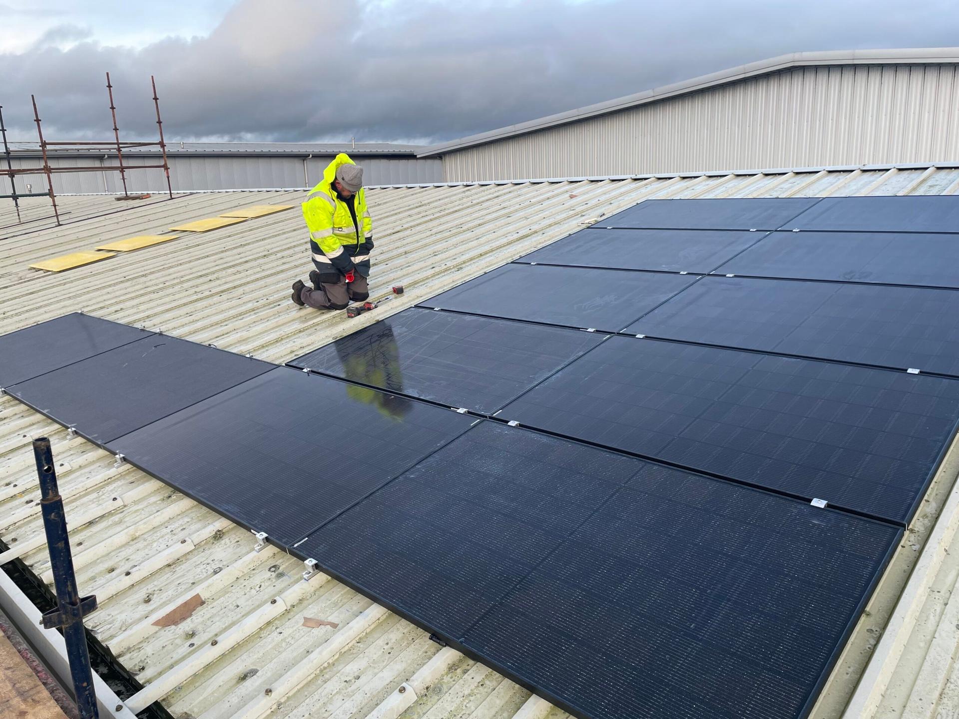 Solar panels being fitted on a commercial roof, a B9 group install